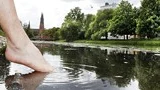 Magnus Olsson badar sin tå i Fyrisån vid Svartbäcksgatan.