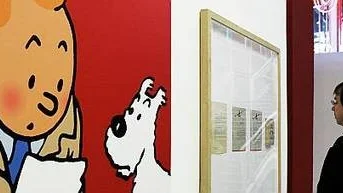 En utställningsbesökare i Paris betraktar en affisch med Tintinoch hans hund i Kongo.