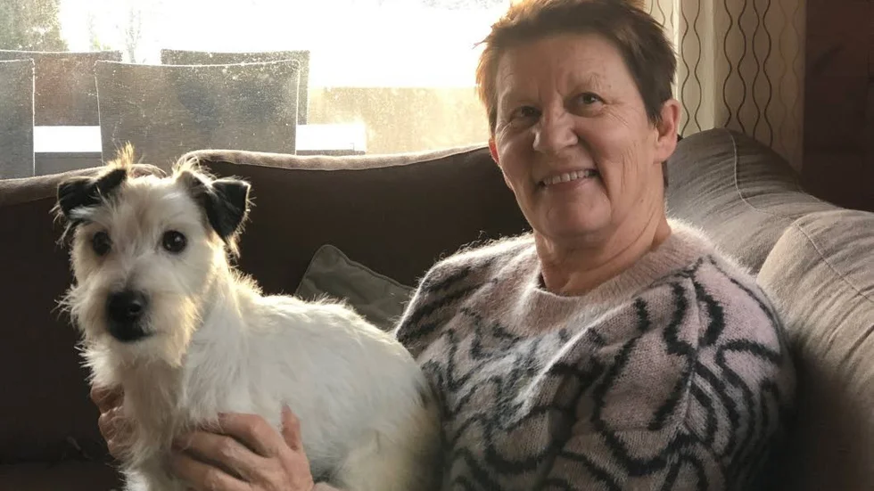 Anita Lehtonen tillsammans med hunden Malte, som också är fast i stugan på Åland.