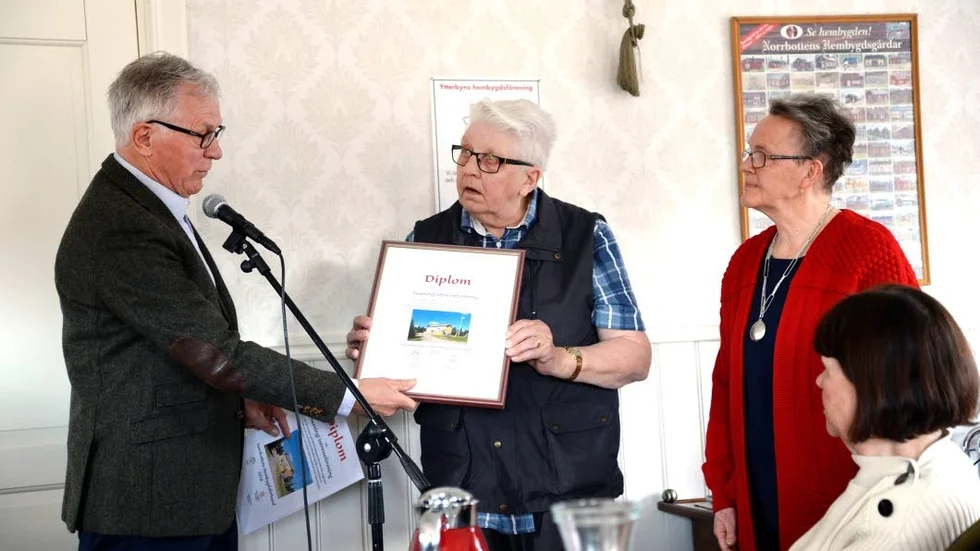 Hembygdsförbundets ordförande Kart Petersen delar ut diplomet till Årets hembygdsförening, Suaningi intresseförening, här representerad av Nils Palovaara och Kristina Laanen.