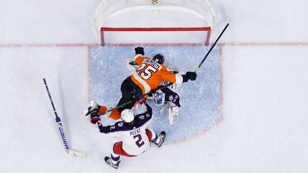 Philadelphias James van Riemsdyk i orange krockar med Columbus Blue Jackets Elvis Merzlikins,till höger och Andrew Peeke. Matchen slutade med förlust för Philadelphia, den tionde i rad.