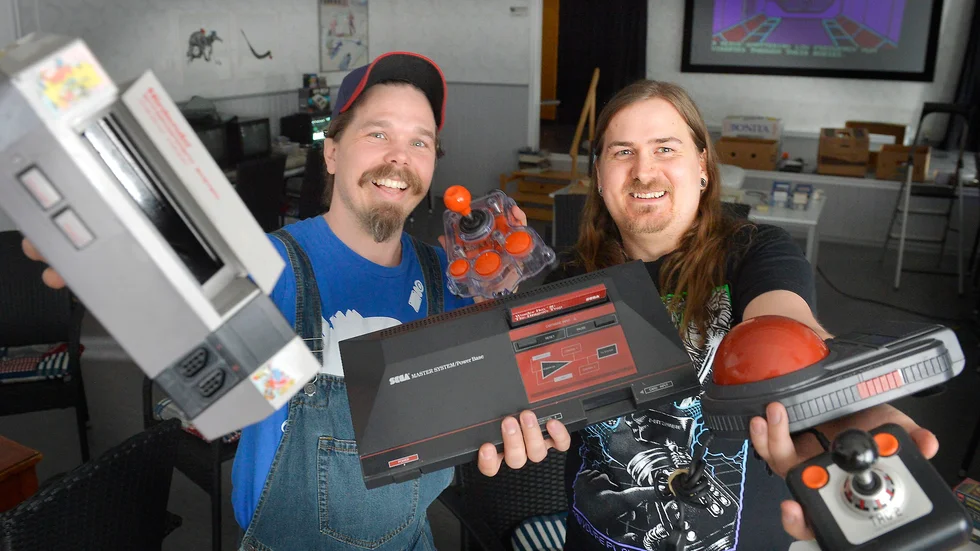 Händerna fulla Thomas och Robert visar upp några gamla konsoler och joysticks. Foto: Jeanette Lövgren.