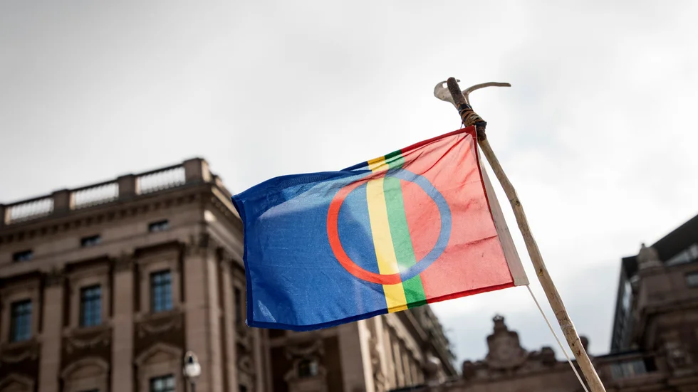 Den samiska flaggan framför Sveriges riksdag. 