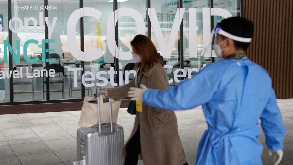 En kvinna som anländer till Sydkorea från Kina blir visad till en plats där hon kan covidtestas på flygplatsen. Arkivbild.