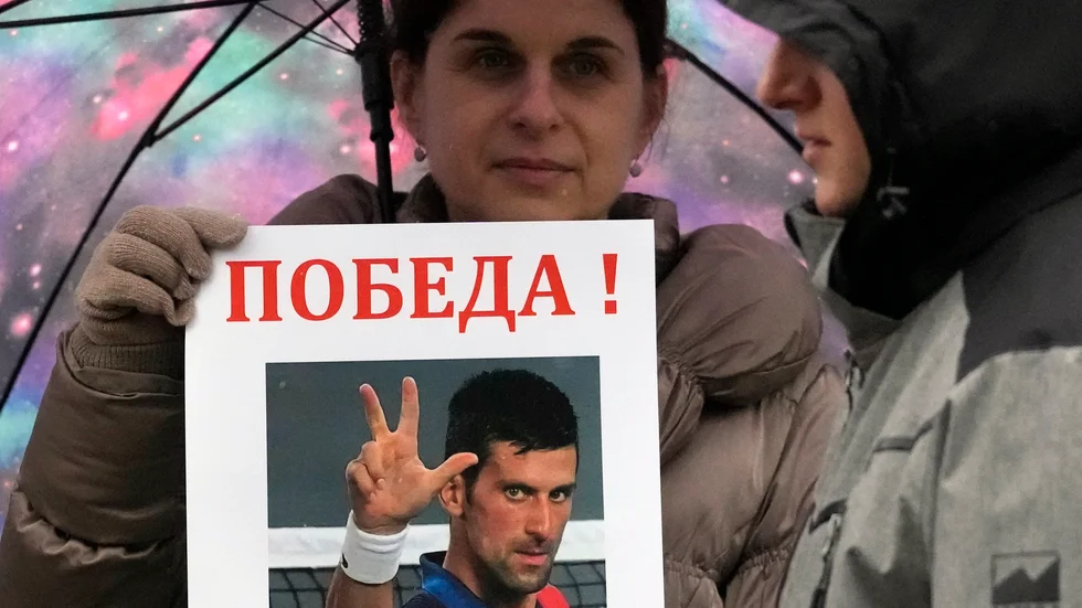 En kvinna håller upp ett porträtt av Novak Djokovic vid en demonstration för tennisspelaren i Belgrad nyligen.. Arkivbild.