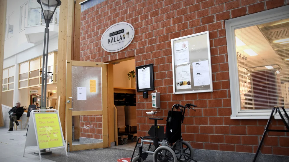 En skylt utanför restaurangens entré informerar om de begränsade öppettiderna. 