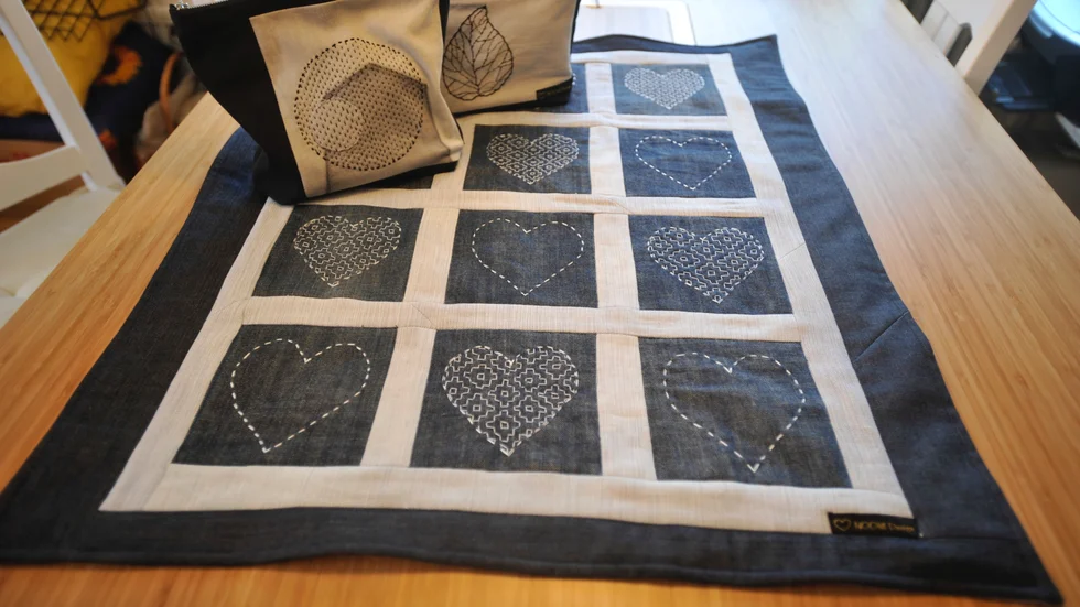 Tekniken "Sashiko" har Noomi tagit till sig. Det ger ett djup och en livlighet till tyget.