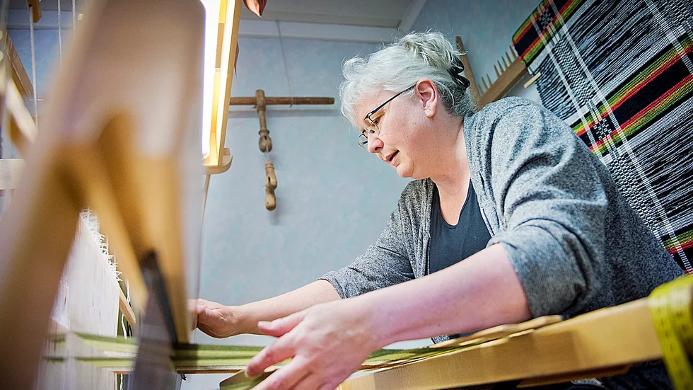 Flitig. I två dagar ska Sylvi Marklund, Skellefteå, hålla sig undan solen och sitta vid vävstolen. Foto: Lars Eriksson.