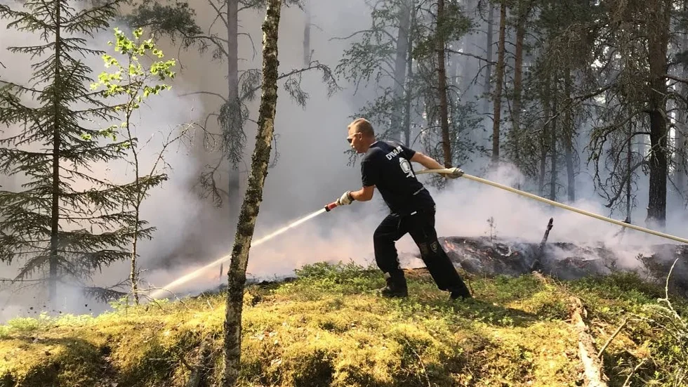 Brandman under pågående släckningsarbete av branden i Vrinneviskogen som startade under tisdagen.