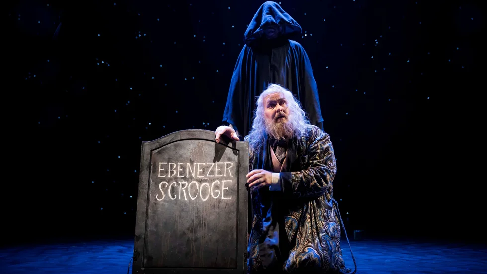 Ebenezer Scrooge (Peter Jansson) vid sin egen gravsten.