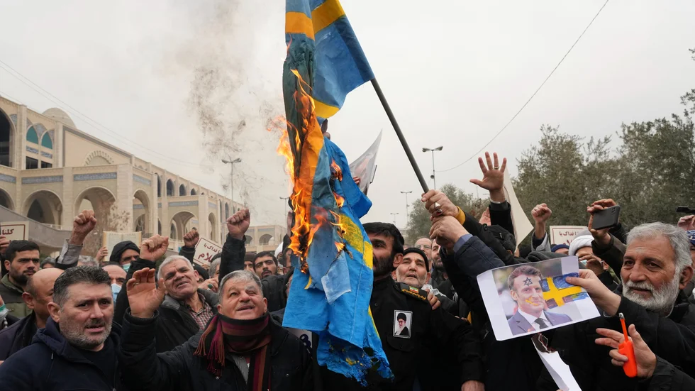 Demonstranter bränner en svensk flagga i Irans huvudstad Teheran.