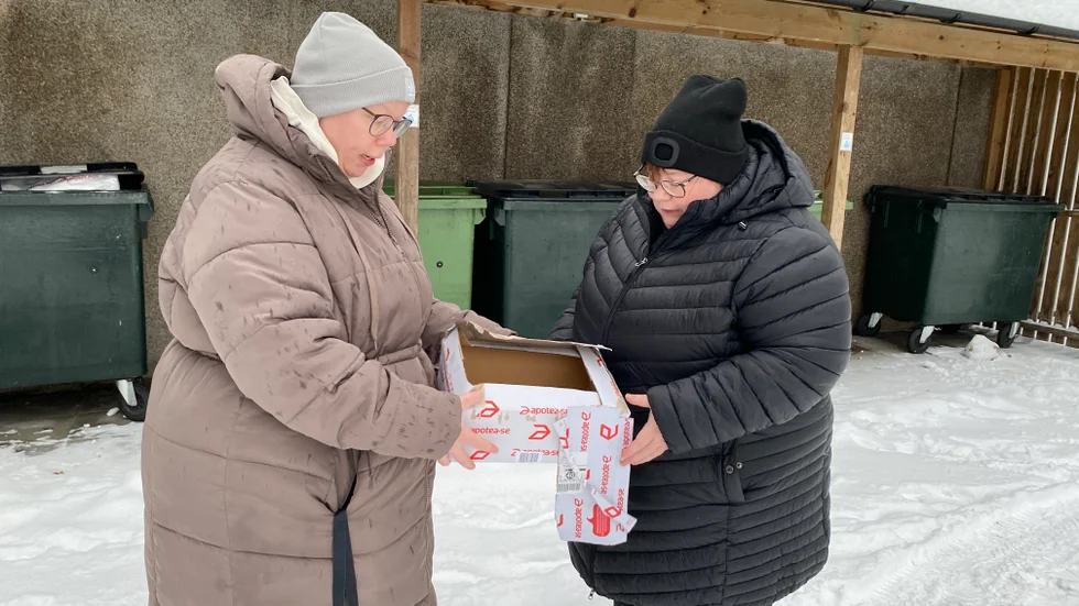 Systrarna Emma Östfelt och Erika Pettersson med paketet, som påträffades i närheten av soptunnorna vid hyreshuset.