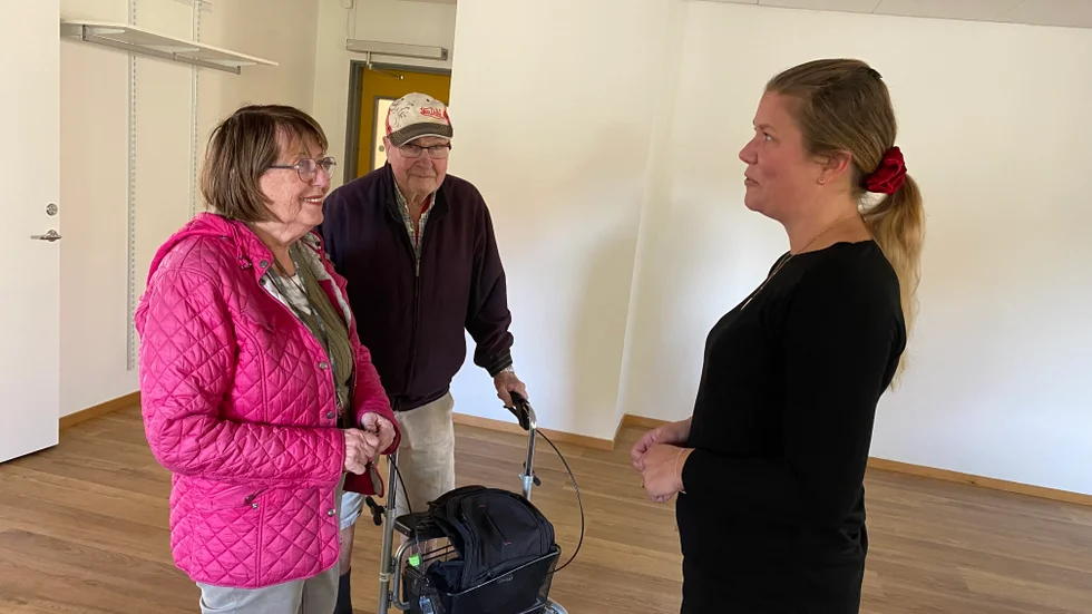Lisbeth Norlander och hennes sambo Olaf Lindström har flyttat in i en trea på femte våningen i trygghetsboendet i Oxelbergen. Här träffar de för första gången aktivitetsledaren Linda Jigholm i gemensamhetslokalen på bottenvåningen.