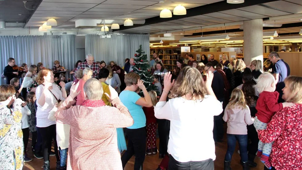 Trångt när biblioteket bjöd på julgransplundring och dans kring granen.