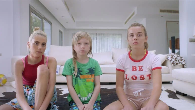 I en av filmens nyckelscener tittar Sascha (Victoria Carmen Sonne,till vänster) på tecknad film på tv medan en misshandel pågår i rummet intill.