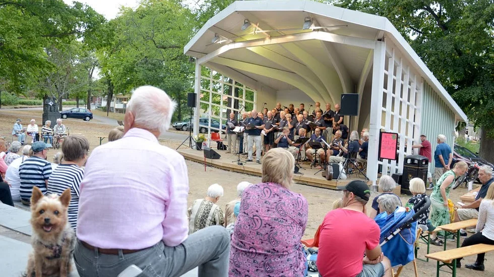 Fullt med folk (och några hundar) på den näst sista allsångskvällen i Stadsparken.