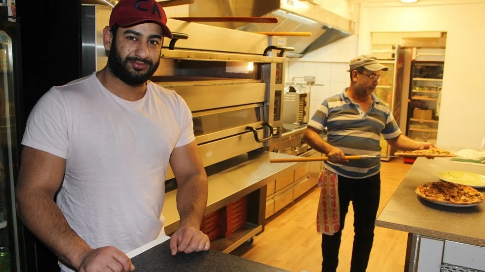 Första pizzorna är bakade i Mörlundas nya pizzeria Charlie. Firas Kareem, med pappa Kareem Abdnor vid sin sida, är förväntansfull. Foto: Charlotte Madestam