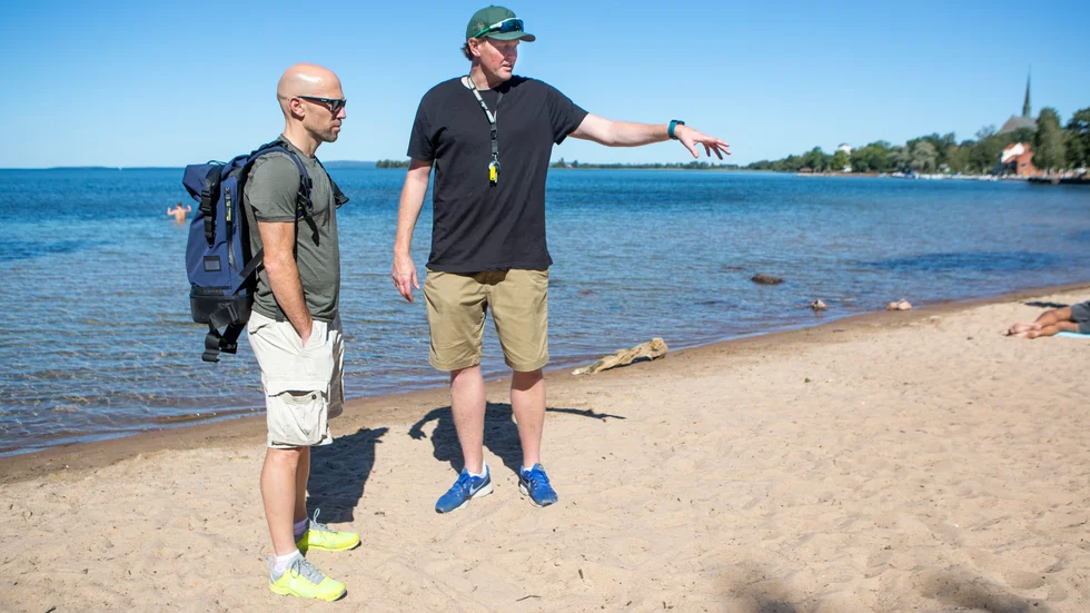 Vadstena triathlons arrangörsgeneral Martin Bengtsson visar hur starten är tänkt att genomföras, för Triathlonförbundets tekniska delegat Matt Richardson, under SM-tävlingarna på lördag.