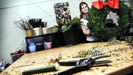 Ta da! Efter en timmas jobb är spretiga grenar förvandlade till en praktfull juldekoration. Jessica Svensson visar upp kransarna ska sprida julglädje i Västervik. På onsdagen monteras de upp på Strandvägen längs med kajen.