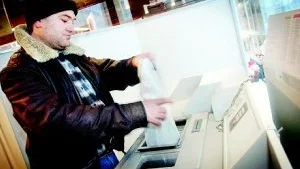Skrammel. Diyap Aksoy tömmer ut sin växelpengar i myntinsättningsautomaten. Han är inte primärt på banken för att göra sig av med mynt som snart blir ogiltiga utan för att han driver Idrottskiosken och sätter in mynt nästan varje dag. Men de senaste dagarna har strömmen av kunder till automaten varit strid och personalen har fått tömma den oftare än vanligt.Foto: Matilda Ahl