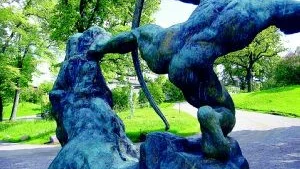 Herkules. Stor och maffig som en klippa i sig ute i trädgården. Mellan hans ben skymtar skulpturen "Bright Future" av Heléne Nordre.