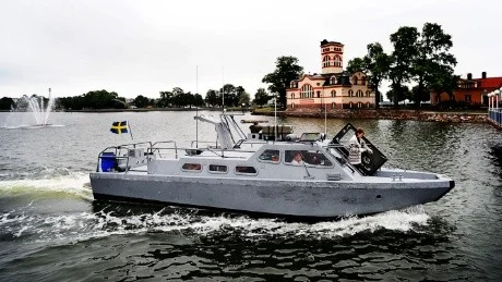 Stridsbåt 90E, med förre Västerviksbon Magnus Holmbom på den högra förarplatsen, på väg in i Fiskarehamnen. På väg ut på fördäck ses sambon Malin Bertilsson. Foto: Ola Axman