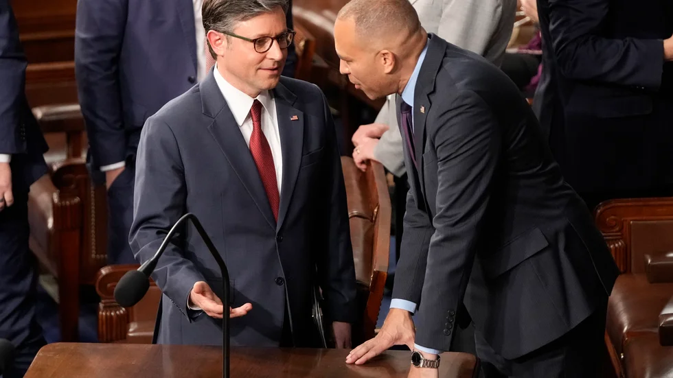 Republikanen Mike Johnson (till vänster) i samtal med oppositionsledaren Hakeem Jeffries i en dramatisk omröstning i representanthuset.