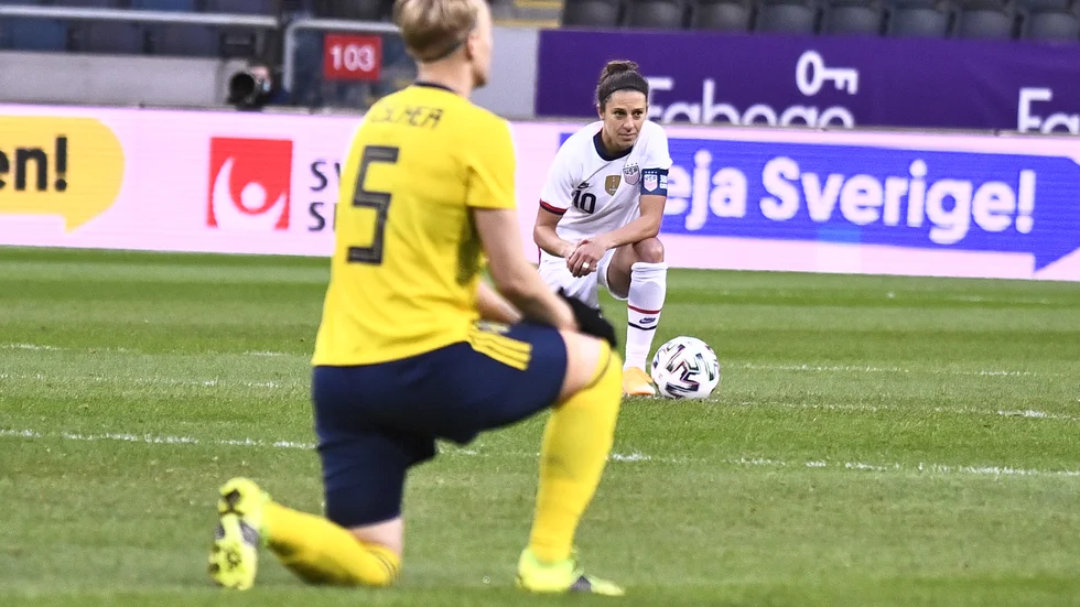 Sveriges Nilla Fischer och USA:s Carli Lloyd knäböjer inför landskampen på Friends arena i april.