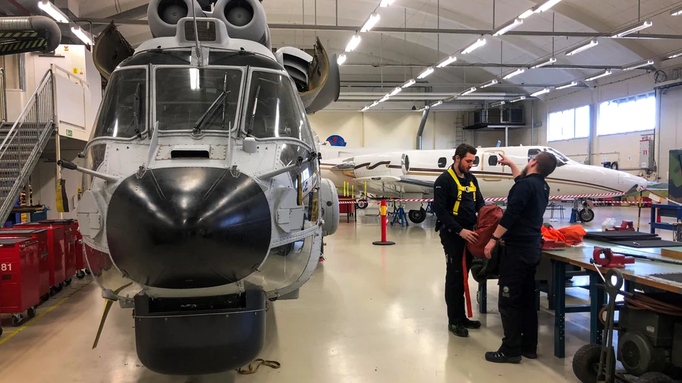 John Jonsson, som läser första året på Yrkeshögskolans flygtekniska utbildning, förbereder sig för att klättra upp på helikoptern.