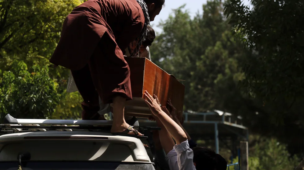 Ett av offren för terrorattentatet lämnar ett sjukhus i Kabul i en kista. Dagen efter självmordsdådet som dödade nära 200 civila afghaner varnar USA för fler attacker.
