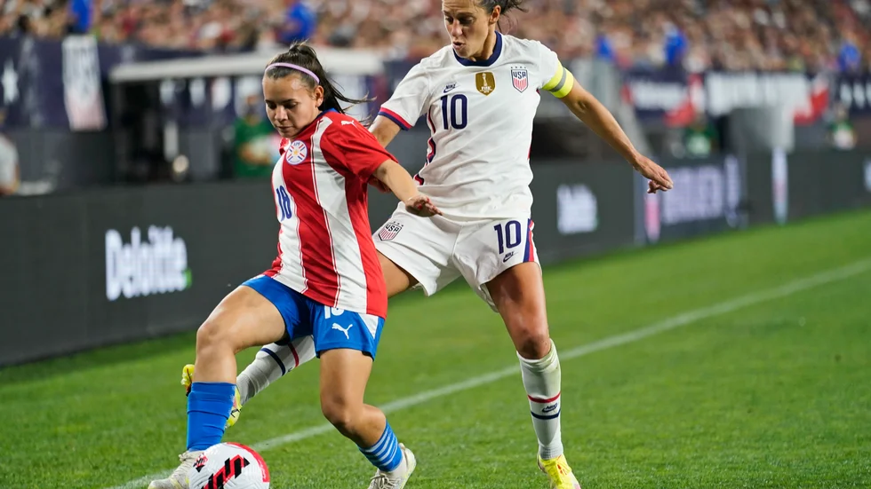 Anfallaren Carli Lloyd i vitt, här i närkamp med Paraguays Ramona Martínez.