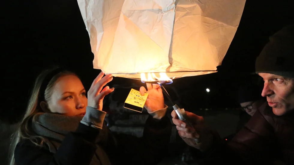 Det är inte alltid så lätt att få fart på himmelslyktorna. Här hjälps Per Lenndin och Agnes Hansius åt vid Norrstrand. De är projektledare respektive projektmedarbetare för Piteå 400 år.