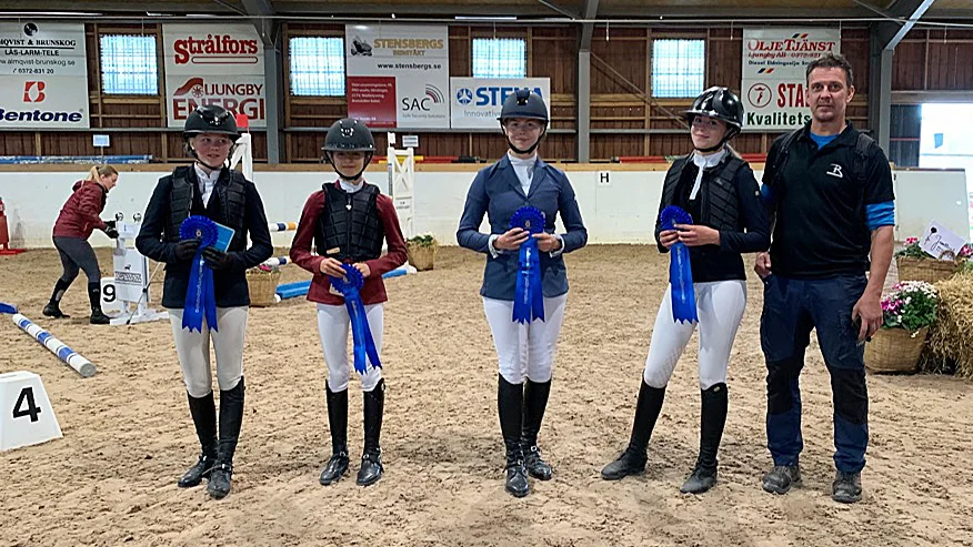 Beda Samuelsson, Lovisa Willenhed, Maja Bergström, Tuva Karlfeldt Ekberg poserar med sin rosetter ihop med lagledaren Stefan Ekberg efter andra platsen i ponnyallsvenskan.