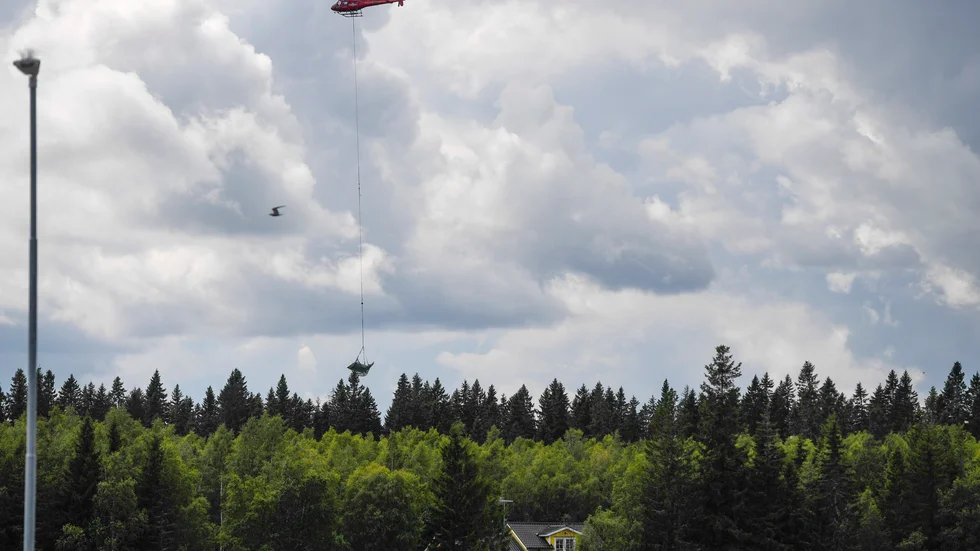 En helikopter bärgar vrakdelar från flygplanet efter olyckan i Umeå 14 juli 2019. Arkivbild.