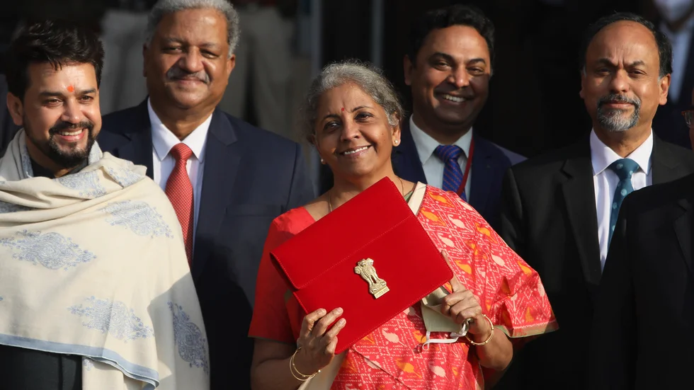 Indiens finansminister Nirmala Sitharaman (i mitten) står med budgeten som nyss presenterats i parlamentet. Bilden togs den 1 februari 2021 i New Delhi. Arkivbild.