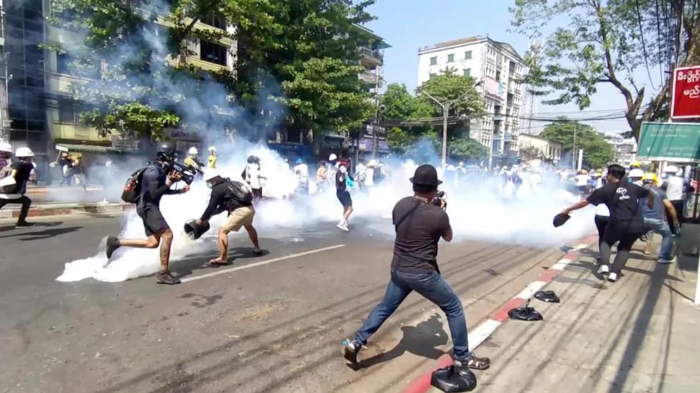 Polis i Rangoon använder tårgas mot demonstranter på måndagen.
