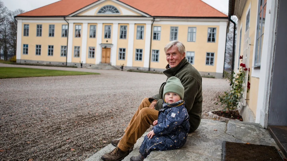 Jan Weijber med ett av barnbarnen, Malcon, på trappan till en av flyglarna. I bakgrunden syns stora huset.