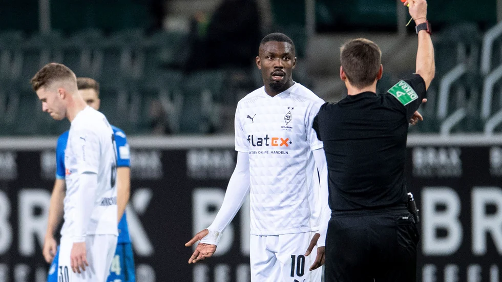 Domaren visar Marcus Thuram det röda kortet efter spottloskan mot Stefan Posch i Bundesligamatchen.