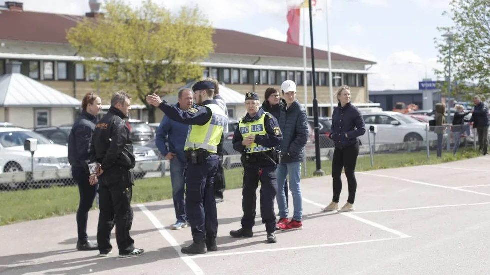 Utrymd skola. Poliser förklarar läget för personal och elever som tvingades lämna sin bombhotade skola.