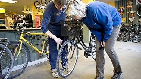 Helena Ramberg får hjälp med en framhjulspunktering   av Mikael Helin på Cykel Viktor.