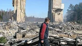 Brandman Jan Levin vaktar de pyrande resterna av den nedbrunna gården i Gunnarsbo, Skärplinge. Foto: Ann Svalander