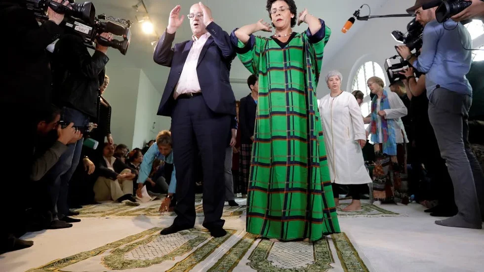 Abdel-Hakim Ourghi och Elham Manea ber framför ett stort medieuppbåd på invigningen av Ibn-Rushd-Goethe-moskén i Berlin, juni 2017. I moskén ber män och kvinnor tillsammans, homosexuella välkomnas och kvinnor kan leda predikan.