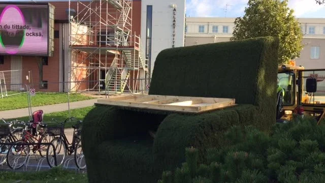 Här fraktas fåtöljen till sin placering under nyhetsskärmen vid Möbeln.