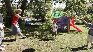 Joakim Palestro, Katarina Pettersson och bröderna Edvin och Simon Pettersson Palestro kastar frisbee i trädgården.