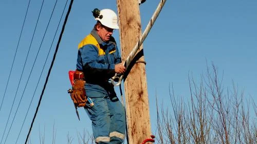 Bengt Karlsson monterar en ny isolerad kabel i Åsbo. Kabeln ska stå emot nedfallande träd. Bild: ANDERS JACOBSSON