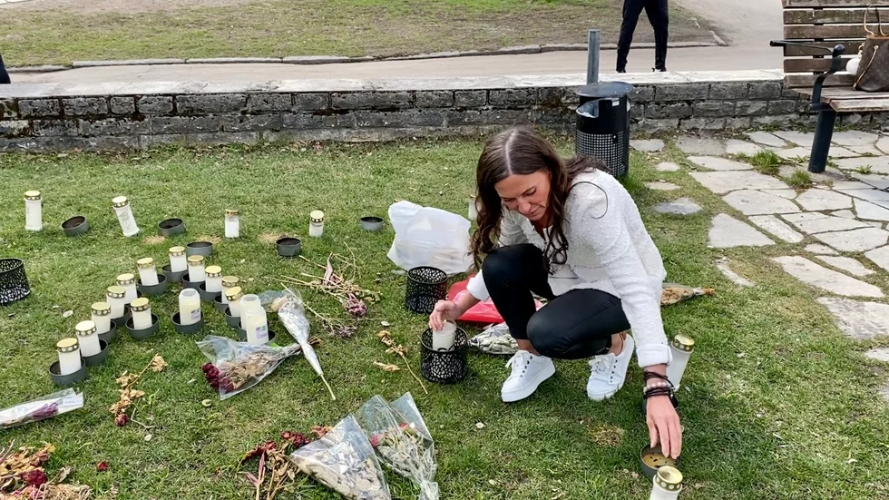 Minette Tigerfalk tänder ett ljus vid minnesplatsen för den man som sköts i Fröslunda för två veckor sedan. Till en början låg minnesplatsen på kullerstenen på torget men flyttades till en gräsplätt för en vecka sedan.
