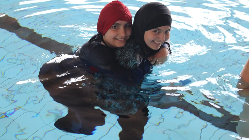 Hanaa Alshaar (12) och Hoda Al Nahywati (14) har kul i vattnet. Nu har de testat att doppa hela huvudet.