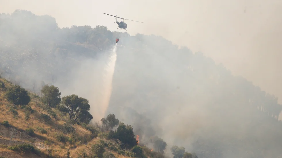 Flera bränder rasade på Sicilien 2021. Här släcker en helikopter bränder i Monte Castillo, Sicilien.