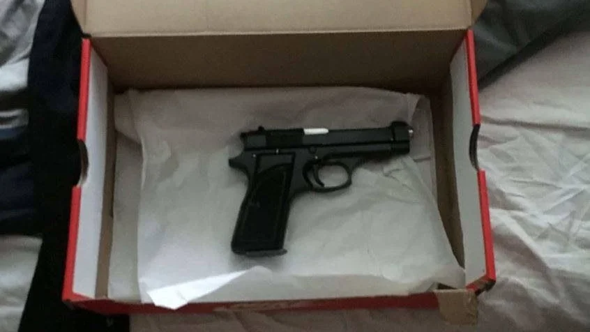 I en skokartong hittade polisen en skarpladdad pistol.