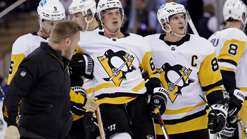 Pittsburghs Rickard Rakell, i mitten, leds av isen efter en hård smäll.